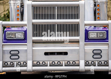 Dark blue commercial long haul American logistic freight leader transportation big rig powerful classic semi truck with grille protection aluminum bum Stock Photo