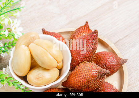 Salak Palm , waive or snake fruit in wooden dish on the table. Stock Photo