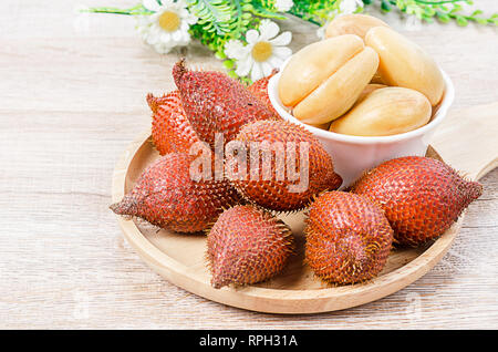 Salak Palm , waive or snake fruit in wooden dish on the table. Stock Photo