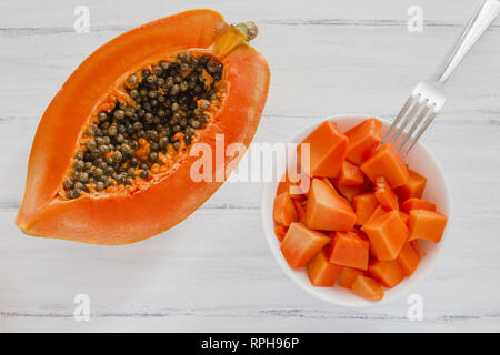 half of papaya fruit on a blue table Stock Photo