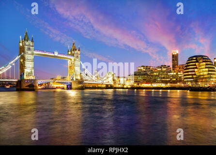 London cityscape at night with famous Tower Bridge illuminated and reflected in Thames river in England - UK