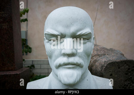 A white marble bust of Vladimir Lenin sits behind a building  in Tallin, Estonia. Stock Photo