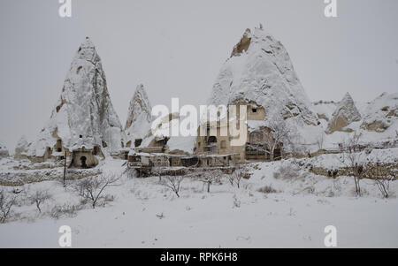 Rock formation in Cappadocia (Valley of pigeons) during a heavy snow fall. Everything covered in pure white snow on a grey snowy day Stock Photo