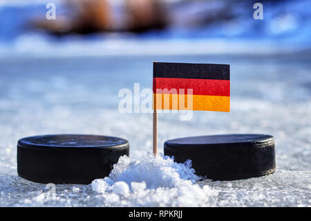 A Germany flag on toothpick between two hockey pucks.  A Germany will playing on World cup in group A. 2019 Ice Hockey World Championship in Bratislav Stock Photo