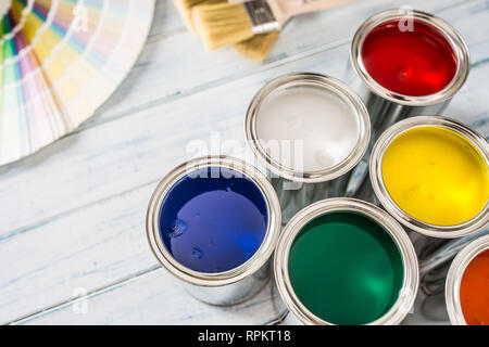 Paint cans brushes and color palette on table. Stock Photo