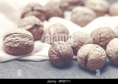 Pretty walnuts large on pink and gray background in sepia Stock Photo