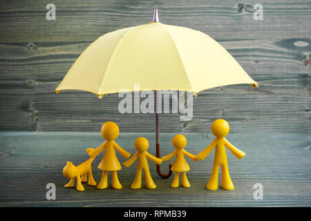 Yellow family figure on green wooden background Stock Photo