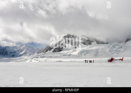 People near the helicopter on Franz Joseph glacier in New Zealand Stock Photo