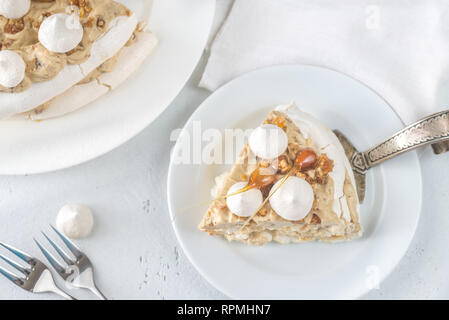 Pavlova cake with caramel and almonds on the wooden background Stock Photo