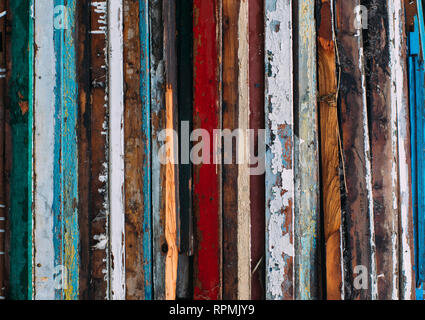 Colorful vertical lines, pile of wooden doors, cracked old paint on wood Stock Photo