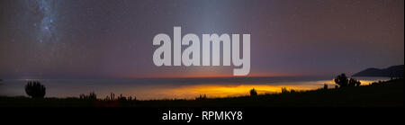 panorama over the mountain range of the coast in the region of Antofagasta. You can see part of the Milky Way and the sunlight that comes out of the h Stock Photo