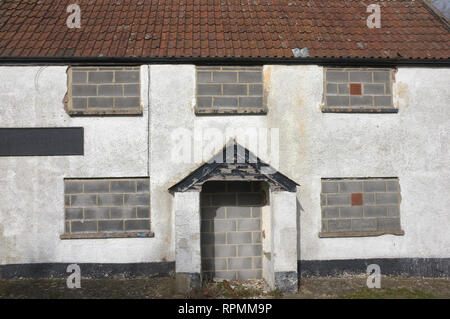 A disused house with bricked up windows and door. Stock Photo