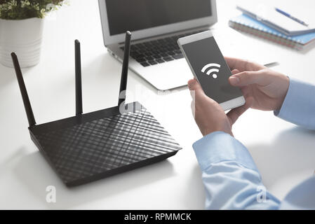 Wireless router or access point. Man using smartphone with wireless symbol Stock Photo