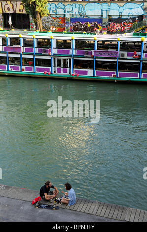 A couple chilling along the Danube canal (Donaukanal) in the summer, Vienna, Austria