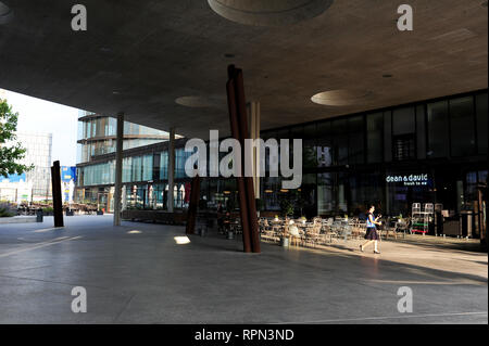 Young woman walking in the new district of Erste Campus, projected by Henke Schreieck studio, Vienna, Austria Stock Photo