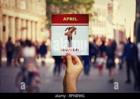 Hand holding a calendar page with 1 april fool's day symbol over crowded  street background. International fun holiday Stock Photo - Alamy