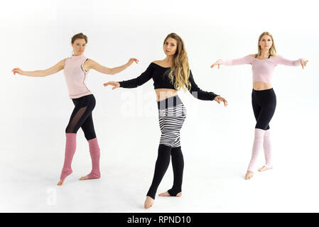 three beautiful young sport girls train yoga pilates, engage in dances Stock Photo