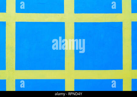 blue wall with painted yellow stripes in many squares. background. texture Stock Photo