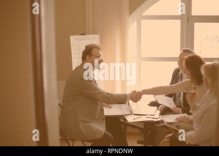 handshake business women and business men near the desktop Stock Photo