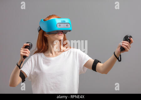 Teenage female in casual wear with VR glasses and joystick having 3D experience, virtual reality concept.