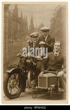 Original 1930's studio portrait postcard of happy men wearing suits and flat caps, posing on motorbike prop, enjoying their annual holiday or leave, dated 20 October 1934, Blackpool, Lancashire, U.K.