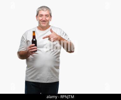 Handsome senior man drinking beer bottle over isolated background very happy pointing with hand and finger Stock Photo