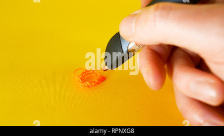 a man's hand draws with a 3d printer pen on a yellow background, footage ideal for topics such as innovation, technology Stock Photo