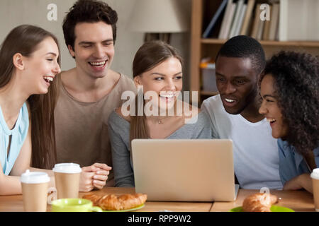 Smiling multiracial people using laptop together, having fun Stock Photo
