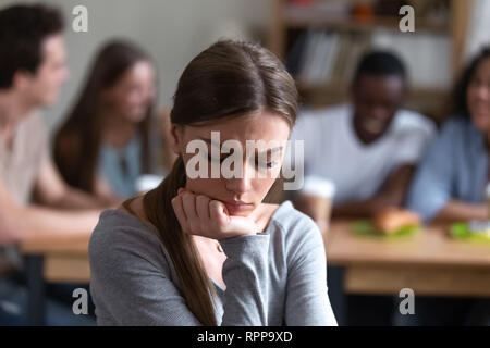 Upset frustrated woman sitting alone, suffering from bullying Stock Photo