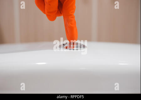 woman's finger pushing button and flushing toilet Stock Photo