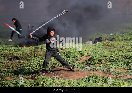 February 22, 2019 - Gaza, Palestine, 22nd February 2019. Clashes occur between Palestinian protesters and Israeli troops in the Abu Safiya area, on the east of Gaza City, during the 48th week of the Great March of Return protests. A 15-year-old boy, Yousef Said al-Daya, was shot in the chest during the protest, and succumbed to his wounds one hour later, while dozens of protesters were also injured by the Israeli army's tear gas and live fire. Thousands of demonstrators have gathered at several points near the fence separating Israel from Gaza this Friday with some burning tyres and throwing Stock Photo