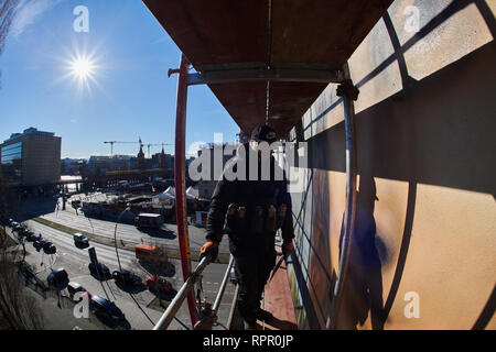 Berlin, Germany. 22nd Feb, 2019. The artist Tank is standing on the scaffold high above, opposite the East-Side Gallery. Together with the Berlin artist collective Die Dixons, he paints the oversized Mona Lisa on the windowless façade of the East Side Hotel. Credit: Annette Riedl/dpa/Alamy Live News Stock Photo