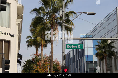 Rodeo Drive street sign in Beverly Hills, California with palm trees in background. This famed road features high-end luxury stores and retailers. Stock Photo