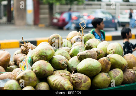 coconut cart on the roadside with children playing in the background Stock Photo