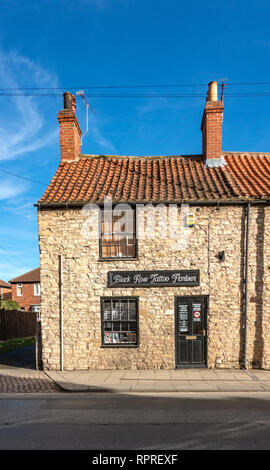 English Village Small stone built shop front called the Black Rose Tattoo Parlour in Market Place, Tickhill in Doncaster in South Yorkshire, England Stock Photo
