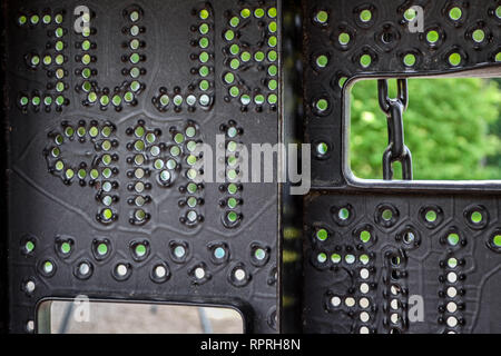 Playground equipment, pierced with metal holes and the Blue Imp company name, viewed from the inside. Stock Photo