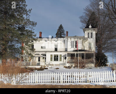 Old fashoined home with white picket fence in winter Stock Photo