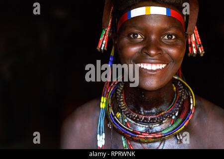 Portrait of a smiling Hakaona (Zemba) woman with traditional ornaments and hairstyle. Namibia, Africa Stock Photo