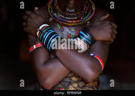 Close up of hands crossed of a Hakaona (Zemba) woman with traditional ornaments and hairstyle. Namibia, Africa Stock Photo