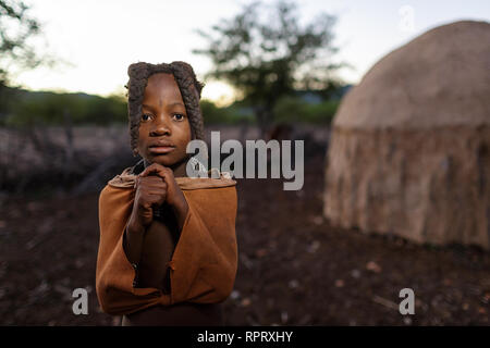 Himba girl with two braids and jewellery, portrait, Himba hut, Himba village, Northern Namibia Stock Photo