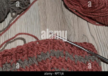 Crochet hook with crocheted beanie. Stock Photo