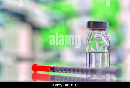 Closeup of medicine vial or flu, measles vaccine bottle with syringe and needle for immunization on vintage medical background, medicine and drug conc Stock Photo