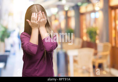 Young beautiful girl over isolated background with sad expression covering face with hands while crying. Depression concept. Stock Photo