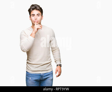 Young handsome man over isolated background asking to be quiet with finger on lips. Silence and secret concept. Stock Photo