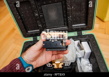 male Technician POV at high-precision optical fiber cleaver for cutting optical fiber very precisely during FTTH home and office - modern internet service provider using high-precision tool. Stock Photo