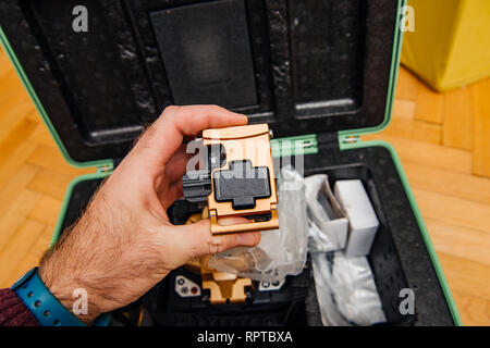 Technician POV at high-precision optical fiber cleaver for cutting optical fiber very precisely during FTTH home and office - modern internet service provider using high-precision tool. Stock Photo