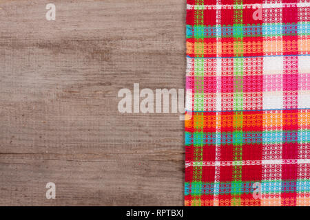 Red checkered tablecloth on an old wooden table with copy space for your text. Top view Stock Photo