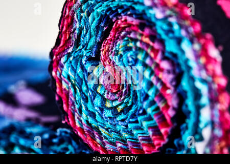 Close Up of Multi-colored remnants of fabric rolled together to create a pattern with shallow depth of field Stock Photo