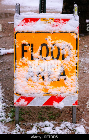 Flood warning sign covered in snow during a rare winter storm in Tucson AZ Stock Photo