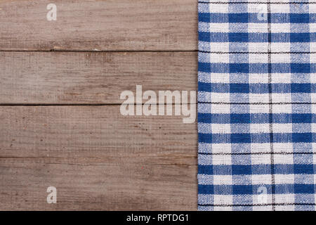 blue checkered tablecloth on an old wooden table with copy space for your text. Top view Stock Photo